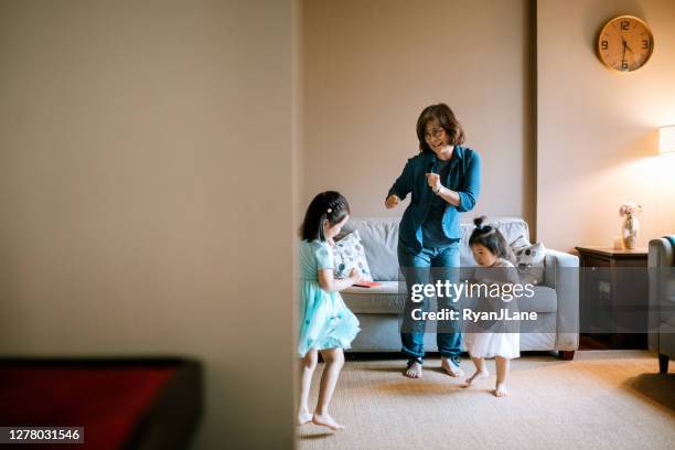 grandmother dances with grandchildren at home - asian grandmother stock pictures, royalty-free photos & images