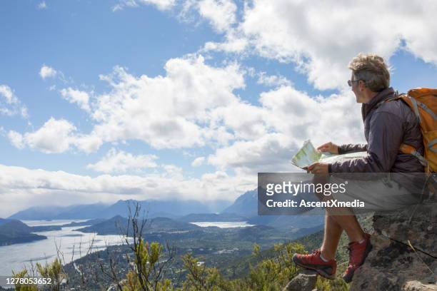男性徒步旅行者在懸崖邊上放鬆,閱讀地圖。 - 德巴里洛切 個照片及圖片檔