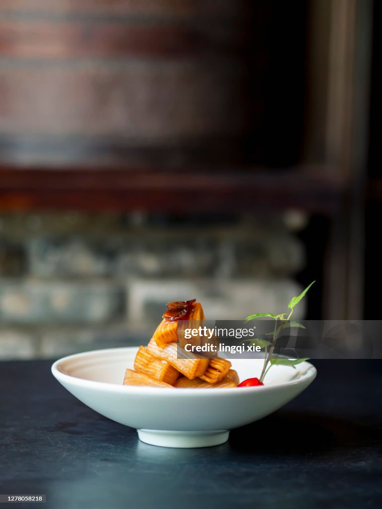 Pickled radish sticks stacked in a tower on a dark background