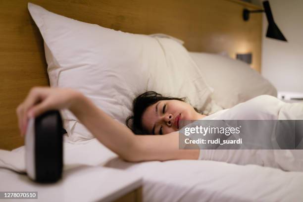 young beautiful asian woman hates waking up early in the morning - fuss stock pictures, royalty-free photos & images