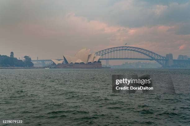 sydney harbour bridge and sydney opera house obscured by smoke from various bushfires across nsw, australia - sydney smoke stock pictures, royalty-free photos & images