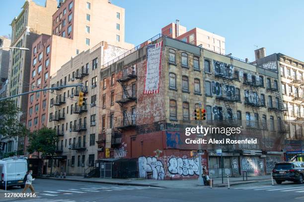 Person crosses the road near a row of abandoned apartment buildings in Chelsea as the city continues Phase 4 of re-opening following restrictions...