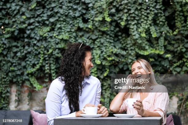 freundinnen im gespräch beim kaffeetrinken - terrassenfeld stock-fotos und bilder