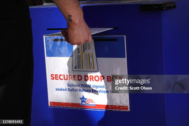 Resident drops off a vote-by-mail ballot in a secure drop box on October 02, 2020 in Chicago, Illinois. The city opened its first early voting site...