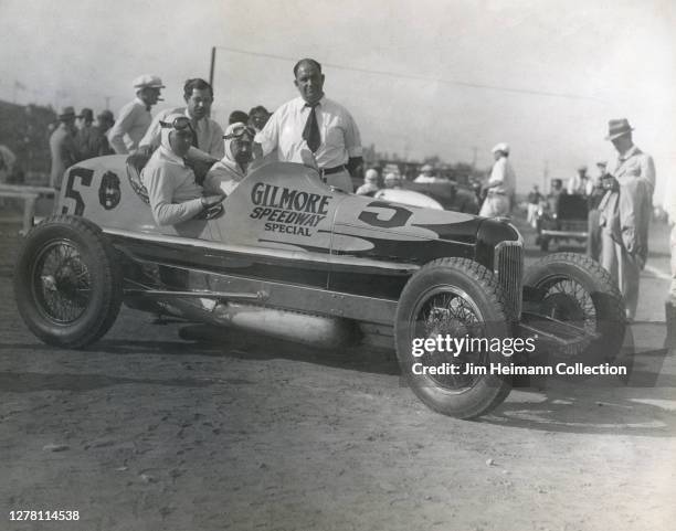 Babe Stapp and a group of men pose with a race car that says "Gilmore Speedway Special" on the side, circa 1935.