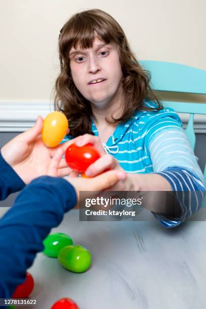 young adult learns how to sort colors with her therapist at home during the covid-19 quarantine - mental disability stock pictures, royalty-free photos & images