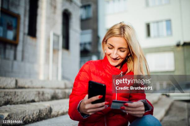 happy young caucasian woman using her smart phone - customer experience stock pictures, royalty-free photos & images