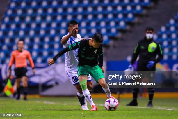 Osvaldo Martínez of Puebla struggles for the ball against Brayan Garnica of Santos during the 13th round match between Puebla and Santos Laguna as...