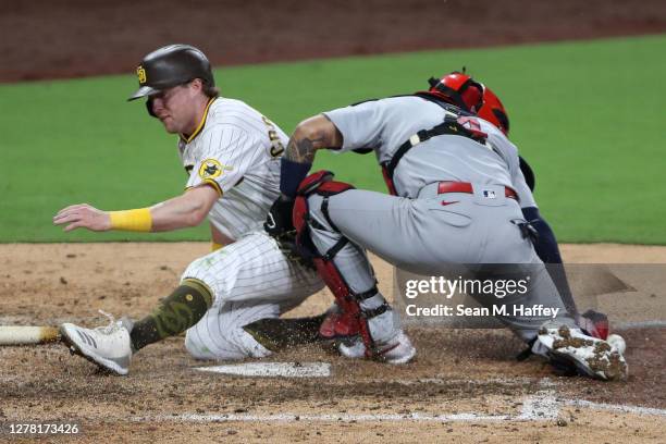 Jake Cronenworth of the San Diego Padres scores a run as Yadier Molina of the St. Louis Cardinals misses the ball during the seventh inning of Game...