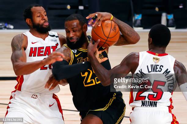 LeBron James of the Los Angeles Lakers drives to the basket against Andre Iguodala and Kendrick Nunn of the Miami Heat during the first half in Game...