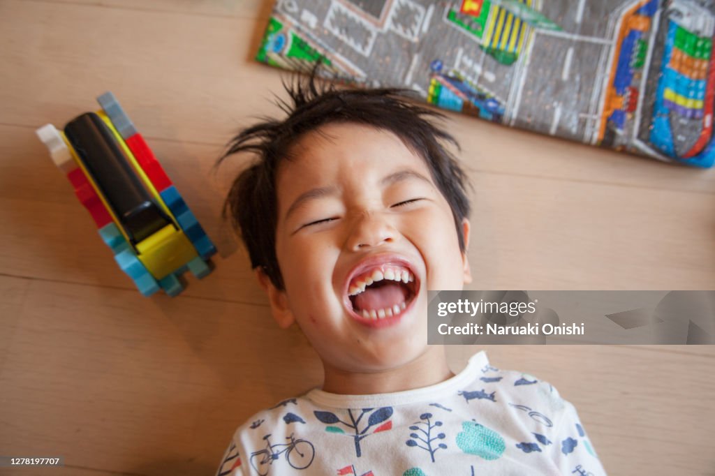 A three-year-old child with a wide open mouth and a big laugh
