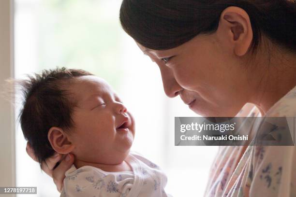 a young mother staring at her baby - angel holding baby stock pictures, royalty-free photos & images