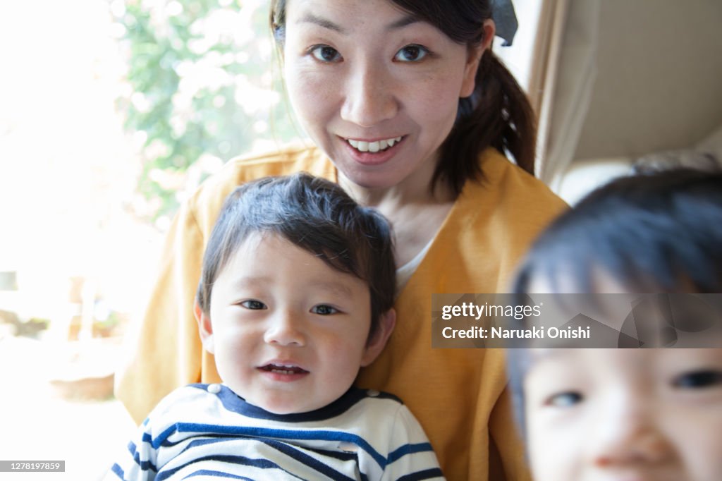 Mother and her little sons relaxing in the living room