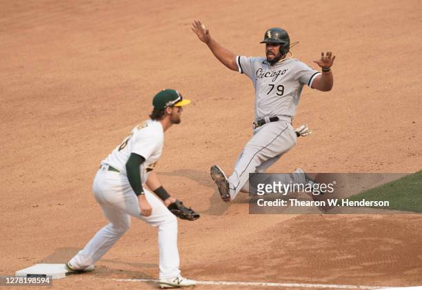 Jose Abreu of the Chicago White Sox slides into third base safe against the Oakland Athletics during the seventh inning of Game Three of the American...