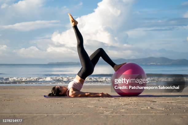 professional training yoga on the beach - yoga ball work 個照片及圖片檔