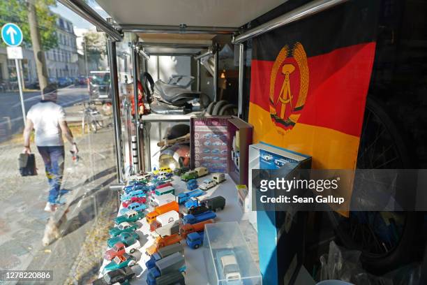 An East German flag hangs in the window of a shop selling East Germany-era motorcycles and memorabilia on the 30th anniversary of German...