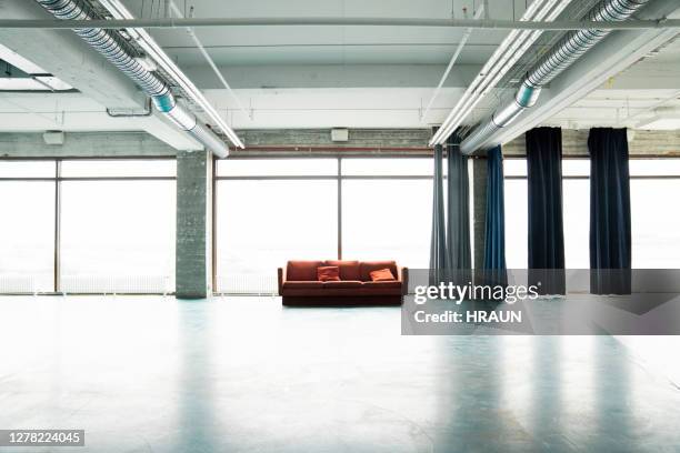 orange sofa by curtain against window at hostel - jumbo hostel stock pictures, royalty-free photos & images