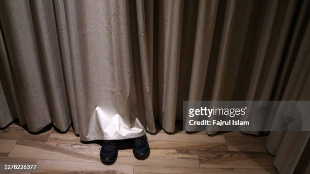 hiding behind the curtain - hiding stock pictures, royalty-free photos & images