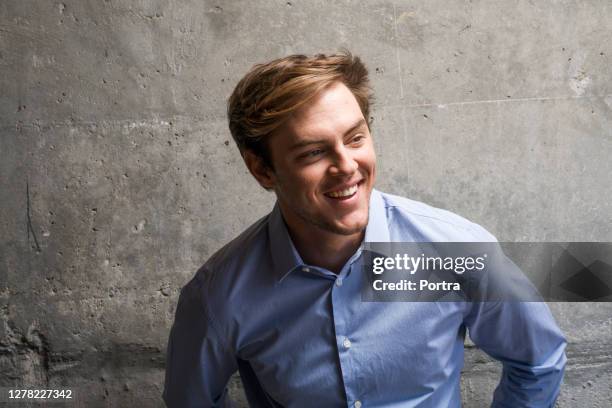 thoughtful smiling handsome man looking away - grey shirt stock pictures, royalty-free photos & images