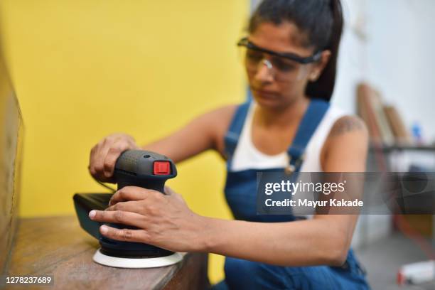 woman using sanding machine - comprehensive renovations stock pictures, royalty-free photos & images