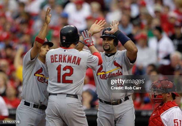 Albert Pujols, Rafael Furcal and Lance Berkman of the St. Louis Cardinals celebrate after scoring on a three-run home run by Berkman in the first...