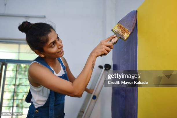 woman coloring interiors of her workshop - indian painting stockfoto's en -beelden