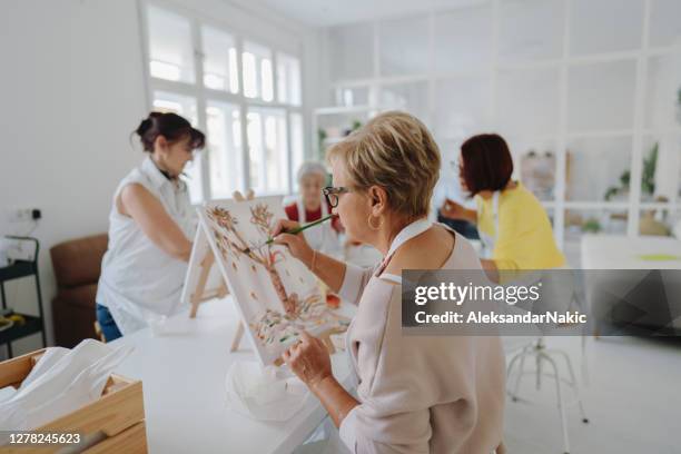 mulher sênior pintando em aula de arte - desenhar atividade - fotografias e filmes do acervo