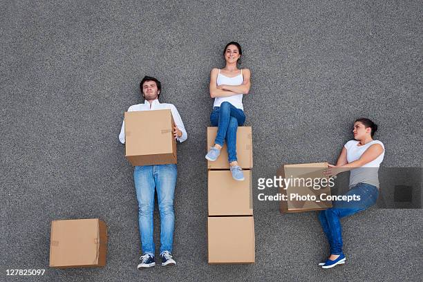 menschen mit karton kartons - lying on side stock-fotos und bilder