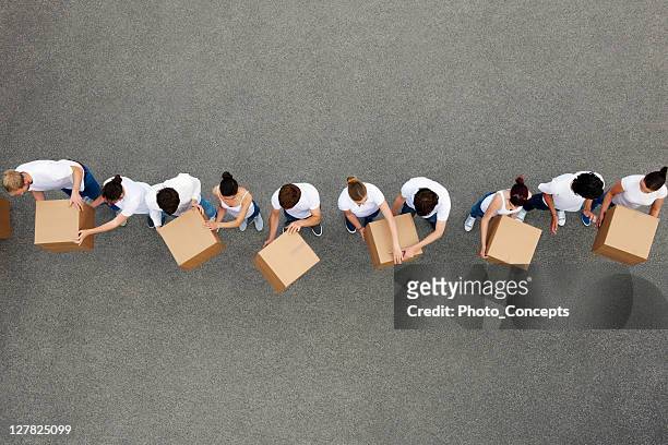 people passing cardboard boxes - organised group stock pictures, royalty-free photos & images