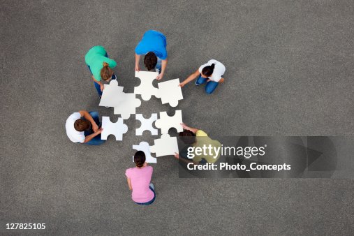 People putting together jigsaw puzzle People putting together jigsaw puzzle
