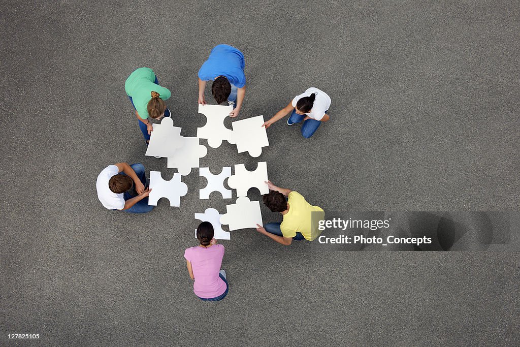 People putting together jigsaw puzzle