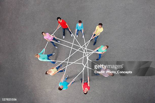people playing with tangled string - medium group of people stock pictures, royalty-free photos & images
