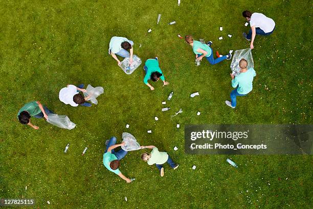 menschen aufräumarbeiten einstreu auf gras - collection stock-fotos und bilder