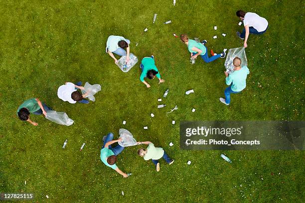 persone pulizia di rifiuti in erba - sollevare foto e immagini stock