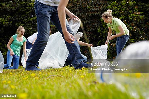 people cleaning up litter on grass - dedication stock pictures, royalty-free photos & images