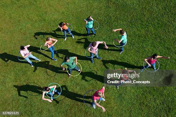 menschen hula-hoop auf gras - gymnastikreifen stock-fotos und bilder