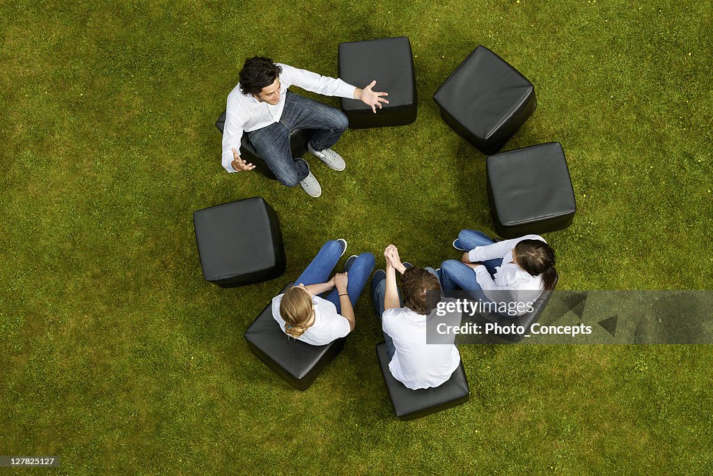 People talking in circle in grass