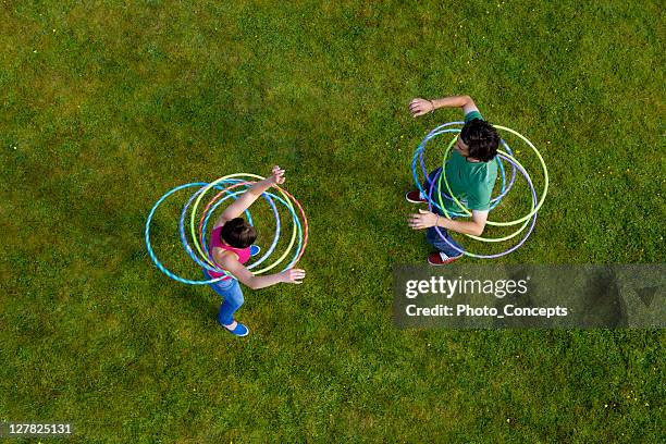 mulher e homem de hula hooping em relva - jogar ao arco imagens e fotografias de stock