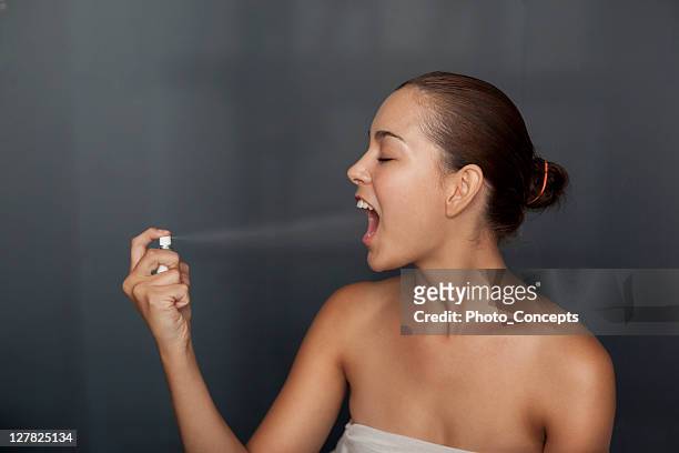 woman spraying breath spray in her mouth - mouth spray stock pictures, royalty-free photos & images