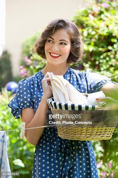 woman carrying basket in backyard - ideal wife stock pictures, royalty-free photos & images
