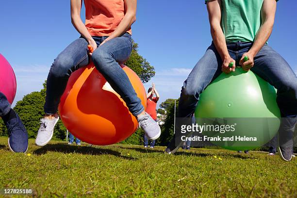 teams racing on exercises balls - hoppity horse stock pictures, royalty-free photos & images