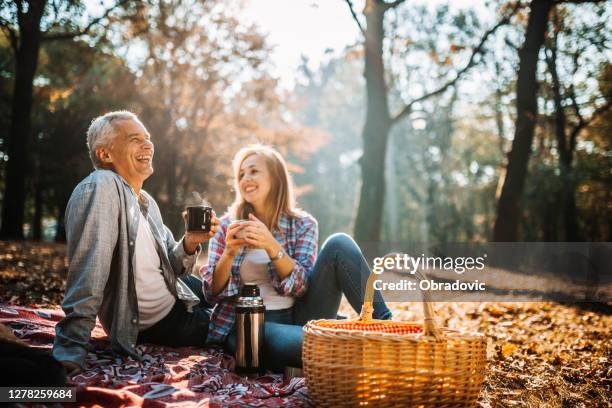 paar genießt picknickzeit an einem schönen herbsttag - paar picknick stock-fotos und bilder