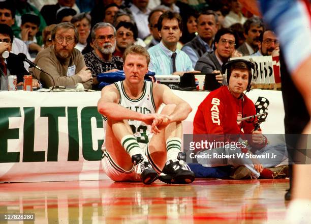 American basketball player Larry Bird, of the Boston Celtics, sits on the sidelines in front of the scorer's table during a game, Hartford,...