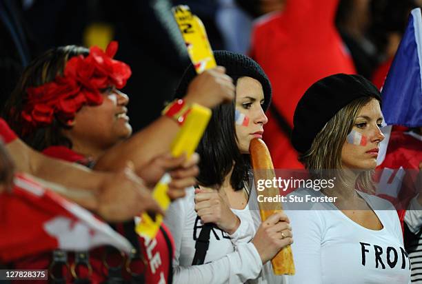 Tonga fan celebrates as dejected France fans look on following their team's 14-19 defeat during the IRB 2011 Rugby World Cup Pool A match between...