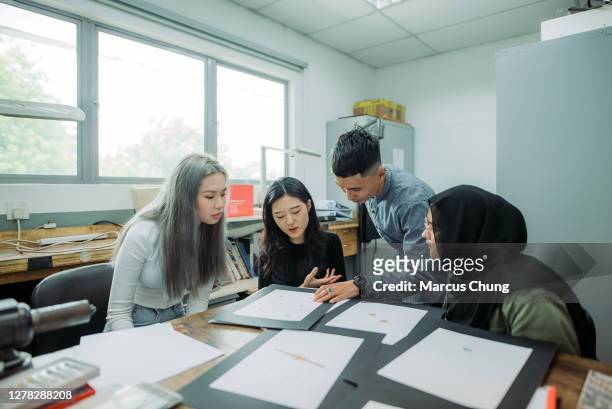 asiatische malay männlichen lehrer hilft seinen schülern im college-klassenzimmer - male teacher in a classroom stock-fotos und bilder