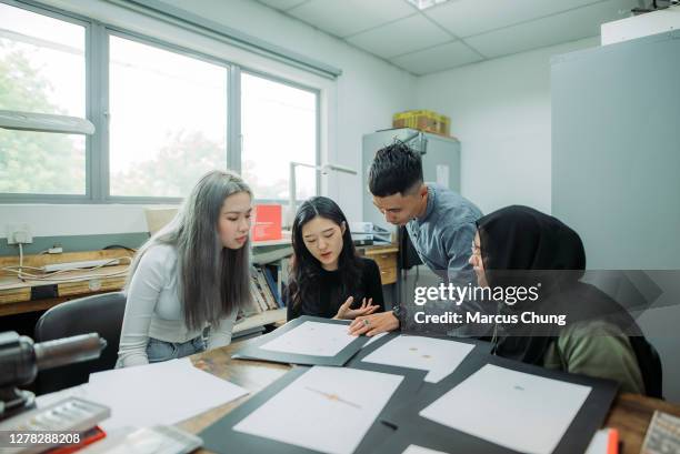 profesor masculino malay asiático ayudando a sus estudiantes en el aula universitaria - male professor with students fotografías e imágenes de stock