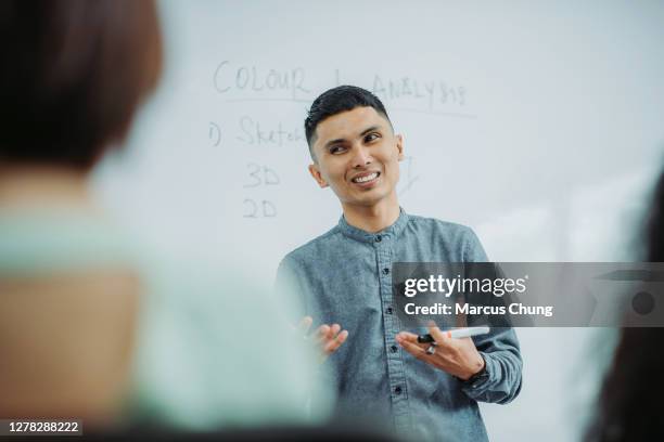 maestro masculino de malayo asiático sonriente dando conferencias a su estudiante en el aula de la universidad - male professor with students fotografías e imágenes de stock