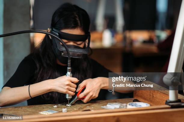 asian korean female student making jewelry at college workbench - jewelry making stock pictures, royalty-free photos & images