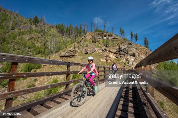 family biking at the myra canyon trestles near kelowna - kelowna stock pictures, royalty-free photos & images
