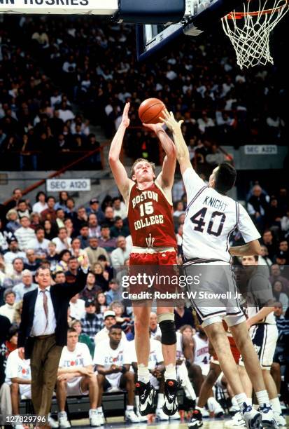 American basketball player Bill Curley of Boston College shoots over defense from Travis Knight of the University of Connecticut, Storrs,...